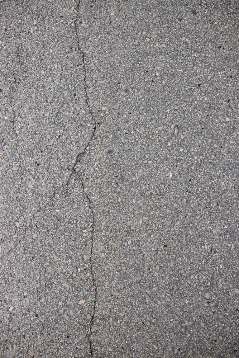 A single crack running through grey asphalt