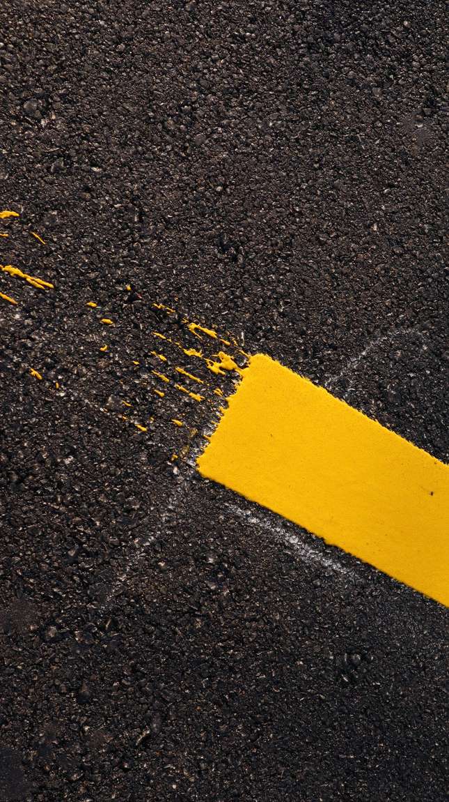 Fresh yellow line paint on asphalt