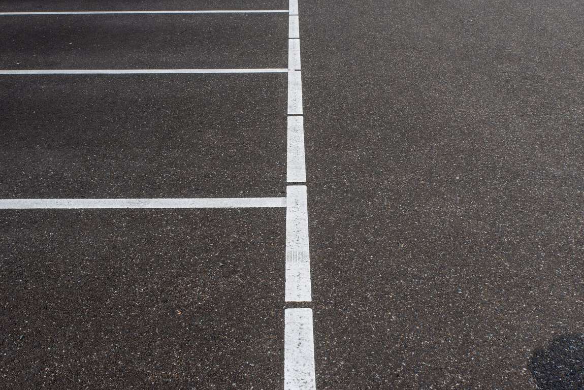 White parking stall lines on dark asphalt