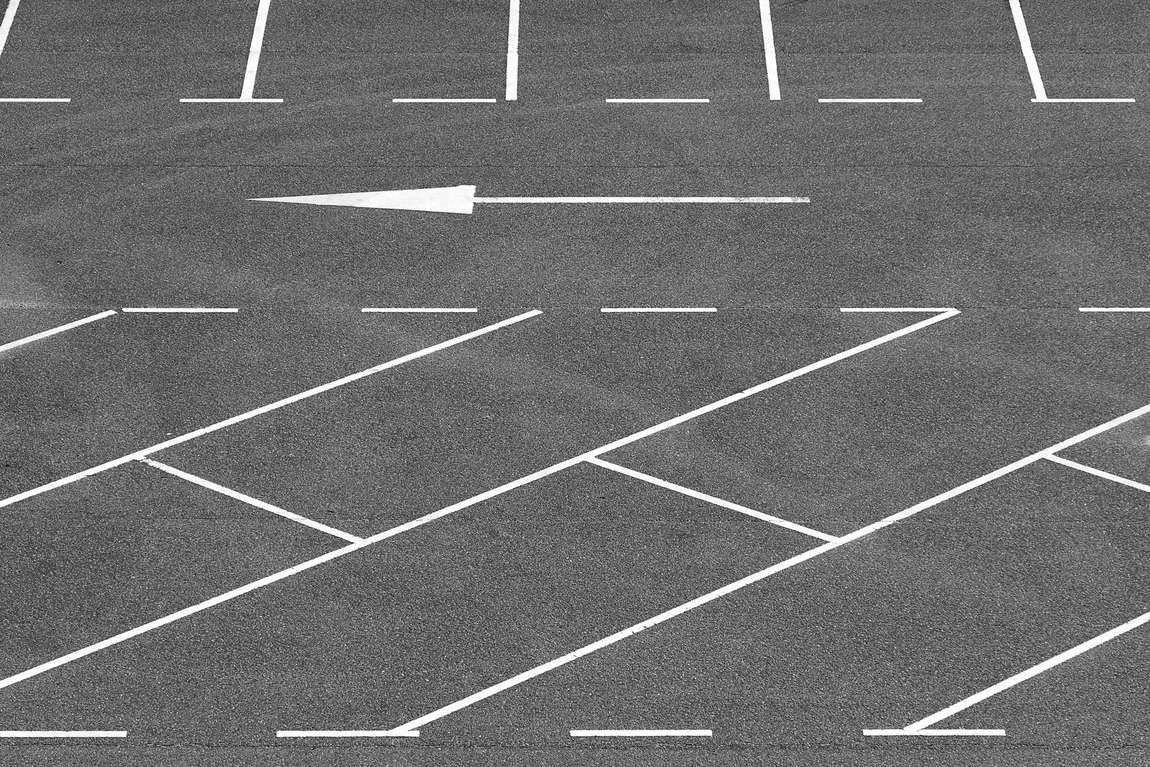 An empty parking lot with a painted arrow and stall lines